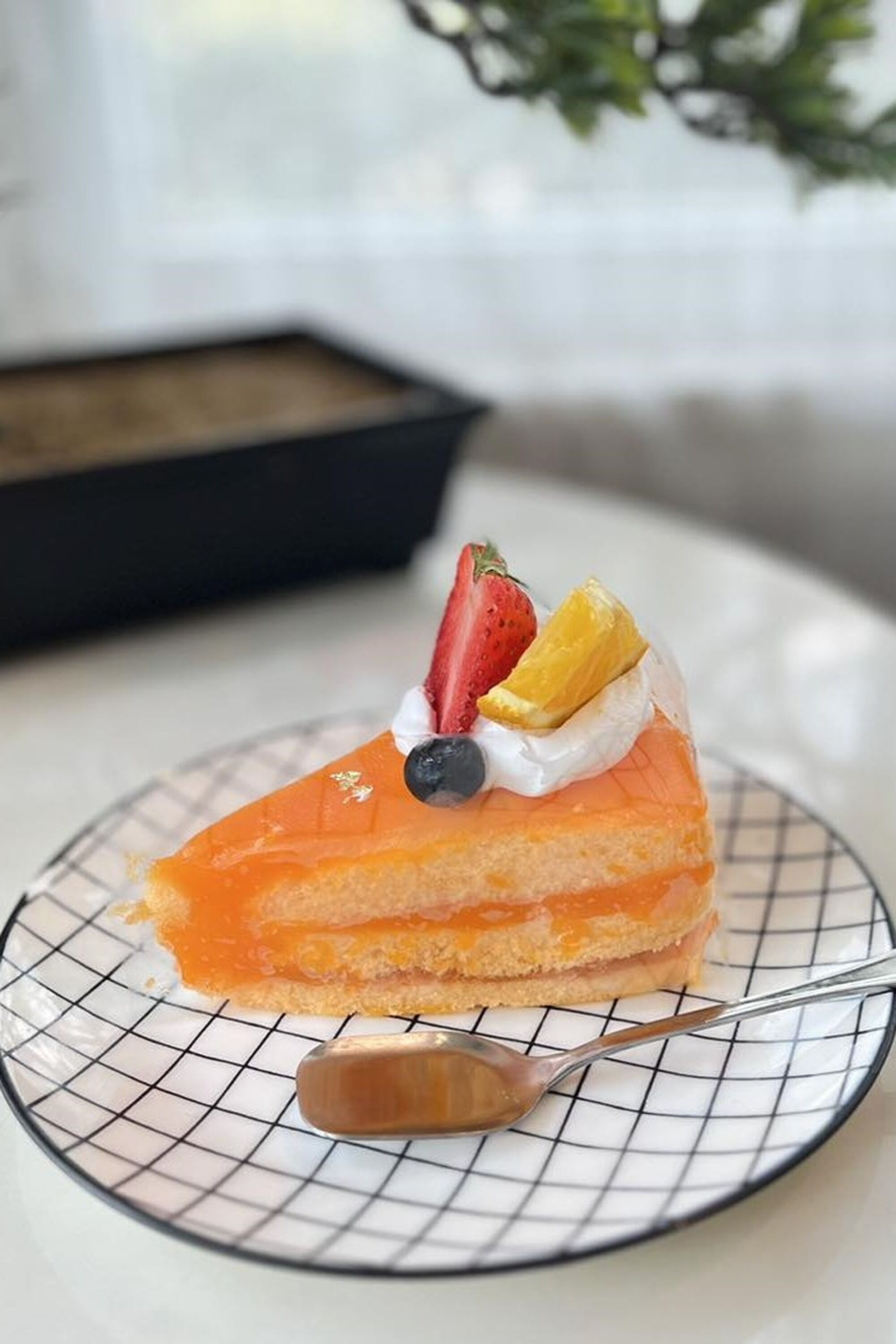 Ein Stück Kuchen mit Obst auf einer Drahtplatte.
