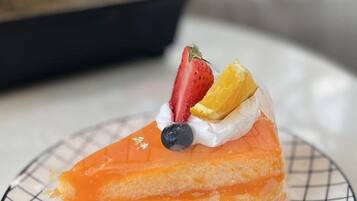 Ein Stück Kuchen mit Obst auf einer Drahtplatte.