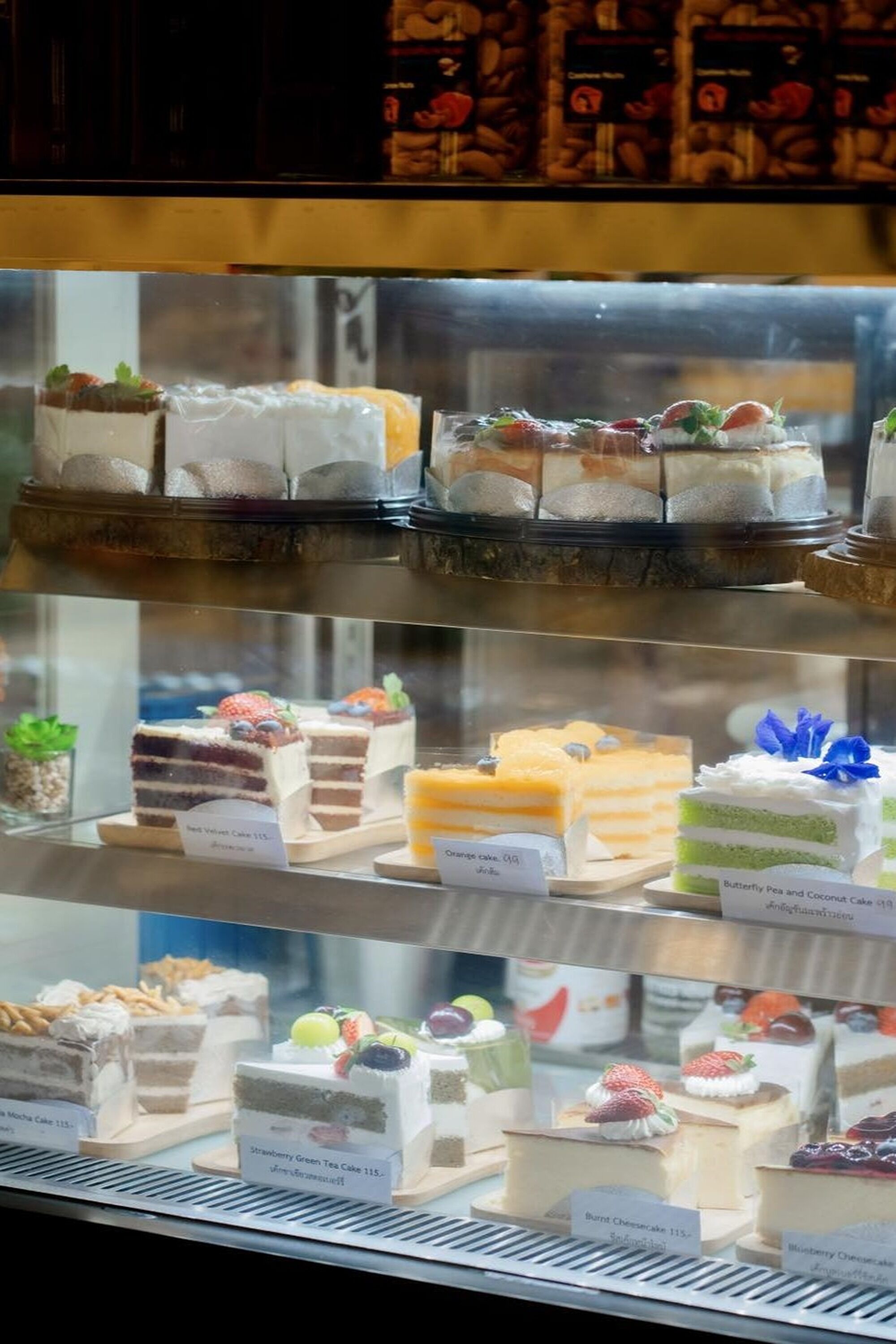 A display case with various types of cakes and desserts.