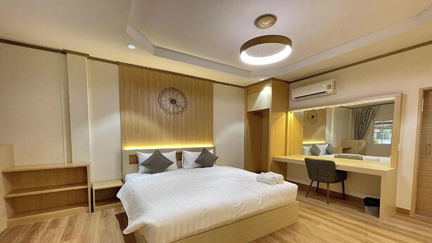 Quarto de hotel moderno com cama, escrivaninha e roupeiro embutido.