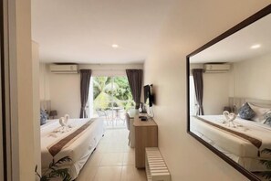 A hotel room with a bed, a desk, a chair, a TV, and a view of the outdoors. - Mystays Phuket (Ko Kaeo)