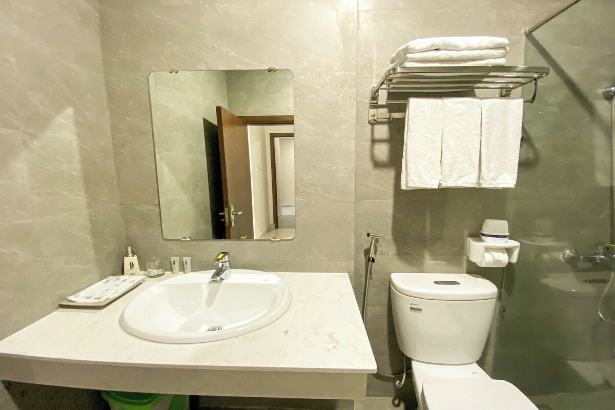 A bathroom with a sink, mirror, toilet, and towel rack.
