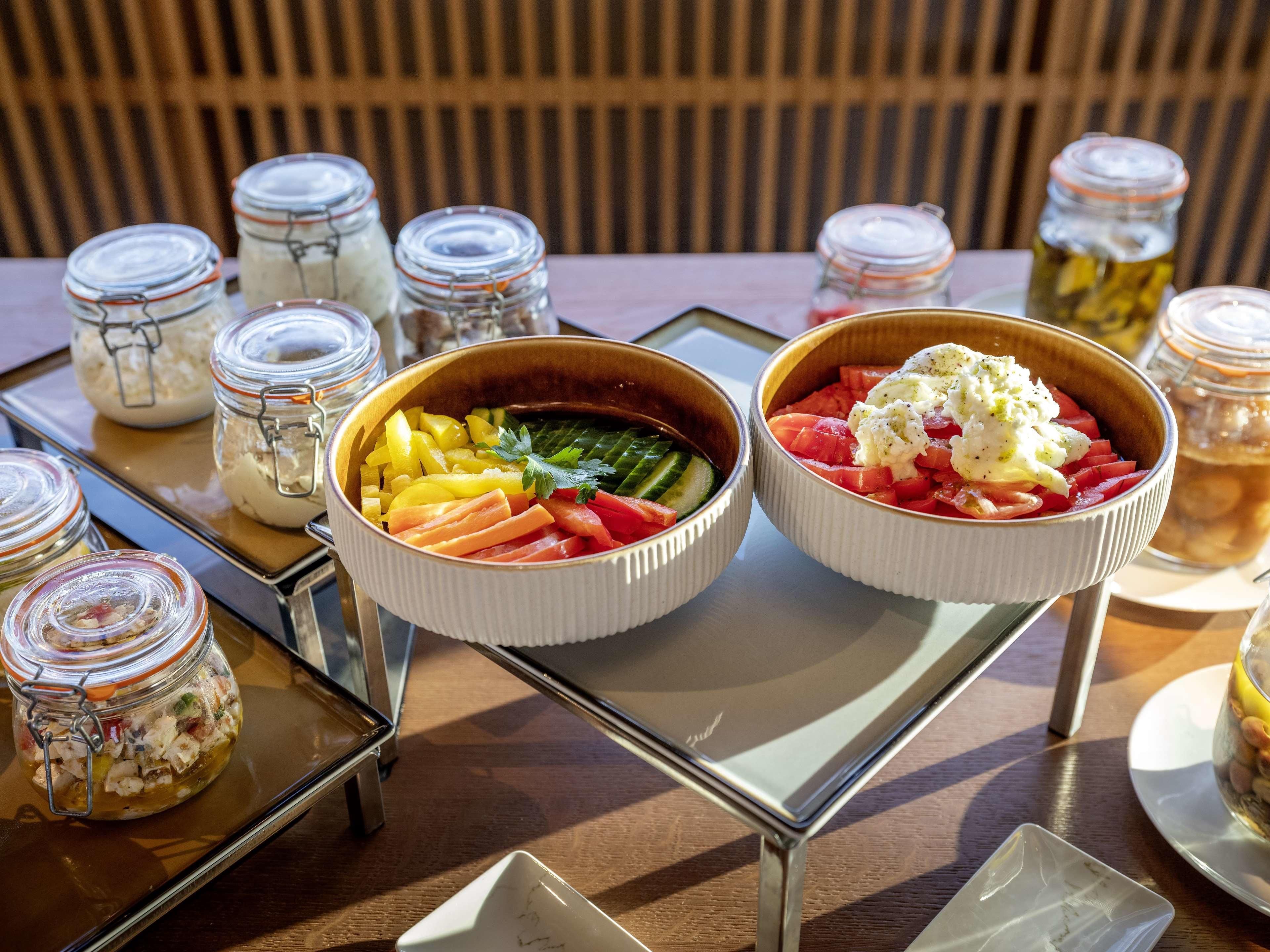 Dos platos de comida sobre una bandeja con frascos de salsas.