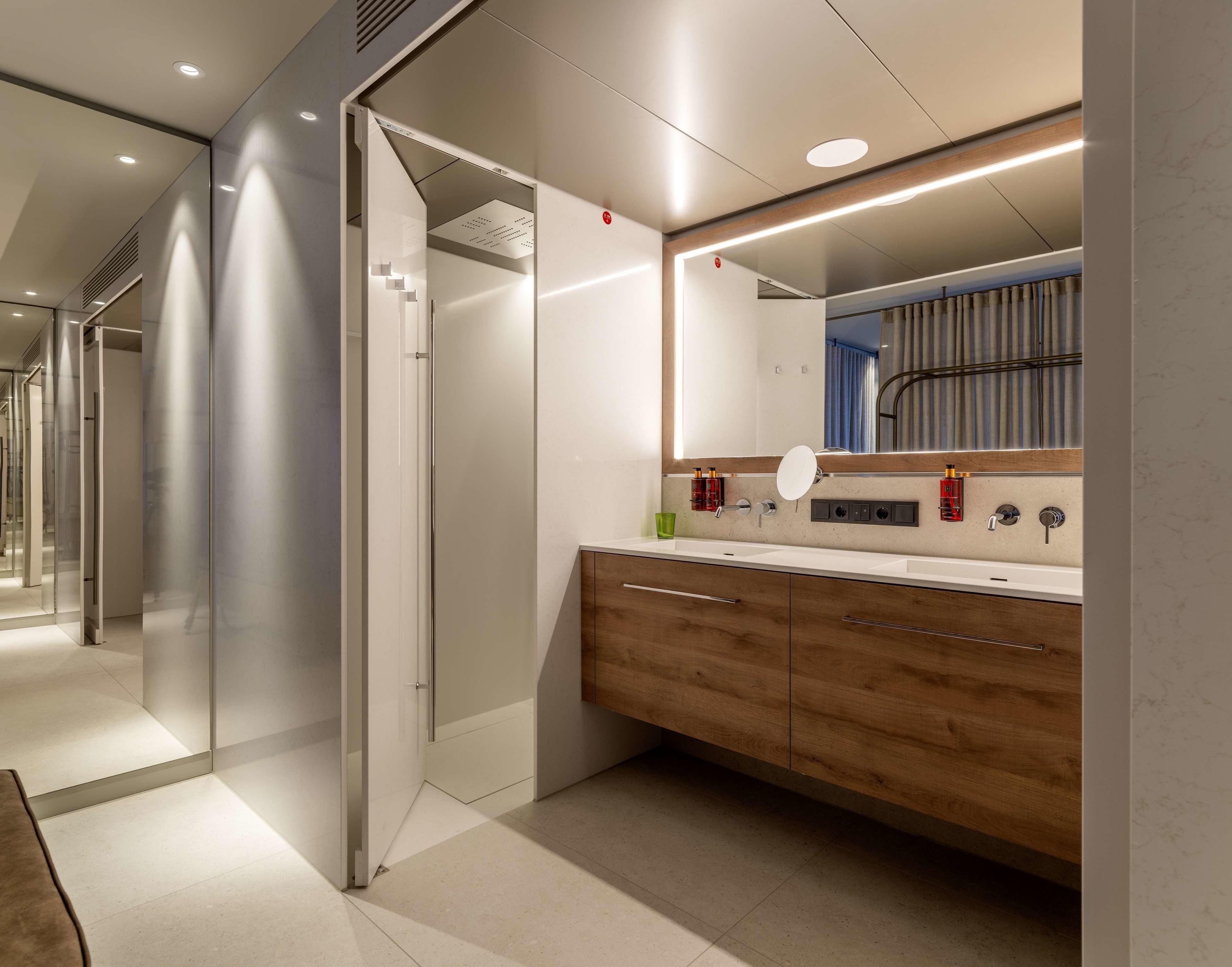 Une salle de bain moderne avec un meuble-lavabo, un miroir et un espace douche.