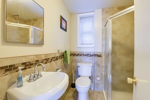 Une salle de bain avec un lavabo, des toilettes et une douche.
