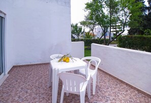 Sit and enjoy the serene surroundings from this cozy outdoor seating area with a table and two chairs.