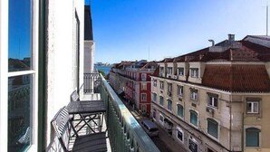 Blick von einem Hochhaus auf eine Straße mit traditioneller europäischer Architektur, einschließlich eines Kirchturms in der Ferne.