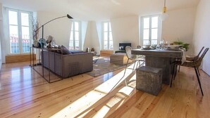 A spacious living area with a sofa, a dining table, and a kitchen area.