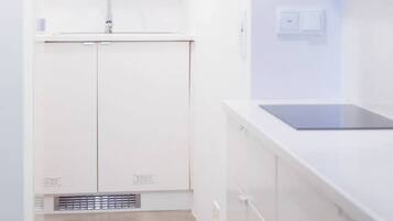 Een moderne keuken met witte kastjes, een spoelbak en een aanrecht.