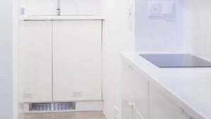 Una cocina moderna con armarios blancos, un lavamanos y una encimera.