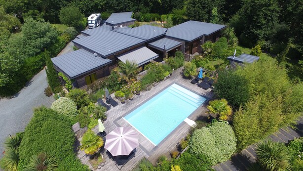 Un resort con varias construcciones, piscina y abundante vegetación.