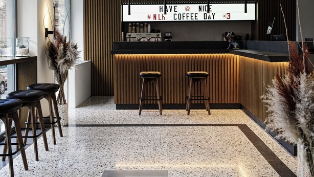 A modern bar area with a neon sign, two stools, and a coffee machine. - NLH KERAMEIKOS - Neighborhood Lifestyle Hotels (Athens)