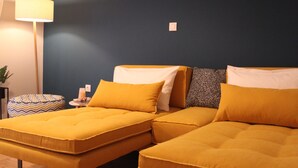Une chambre avec deux lits, une lampe, une petite table et un appareil de climatisation.