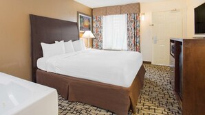 A hotel room with a large bed, a desk, a television, and a bathroom. - Surestay Hotel by Best Western North Myrtle Beach (North Myrtle Beach)