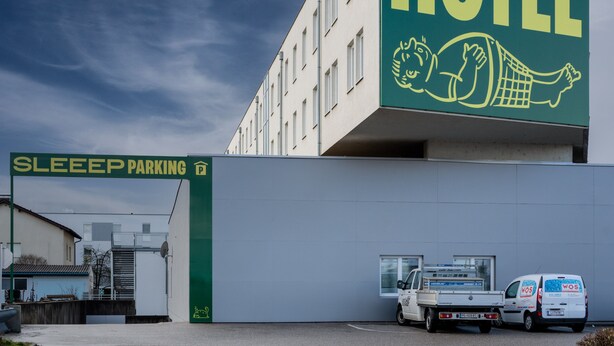Hotel Sleep con un cartel grande y un letrero de Sleep Parking.