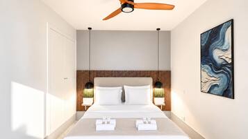Ein modernes Hotelzimmer mit Bett, Deckenventilator, Nachttischlampen und einem Bild an der Wand.