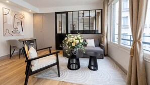 A modern living room with a sofa, a chair, a small table, and a decorative vase. - Champs-Elysées - Prestige flat with lift Matignon (Paris)