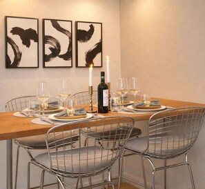 A dining table set with wine glasses, plates, and a candle. - Splendid apartment - Notre Dame Cathedral (Paris)