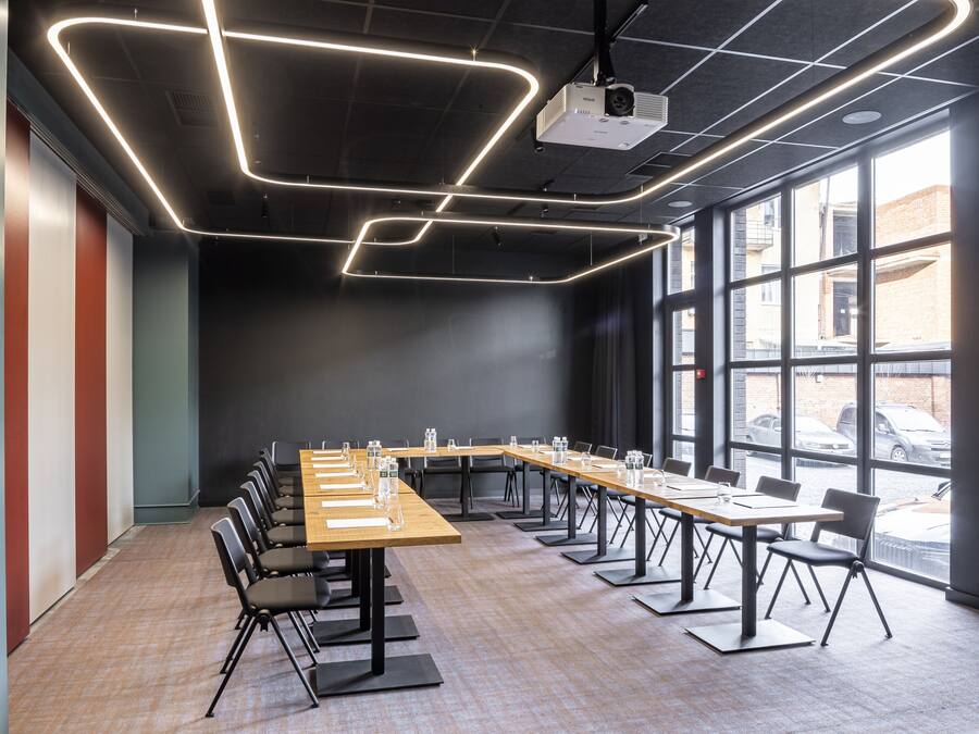 A conference room with a long table, chairs, and a projector.