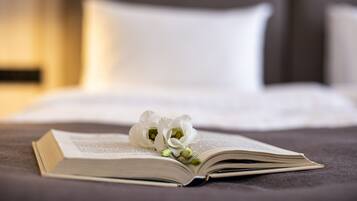 An open book on a bed with white flowers.
