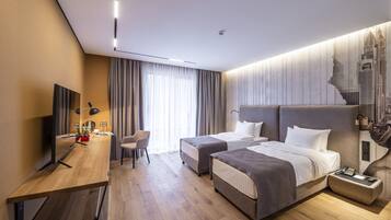 Una habitación de hotel moderna con dos camas, un escritorio, una silla, un televisor y un mural con un paisaje urbano en la pared.