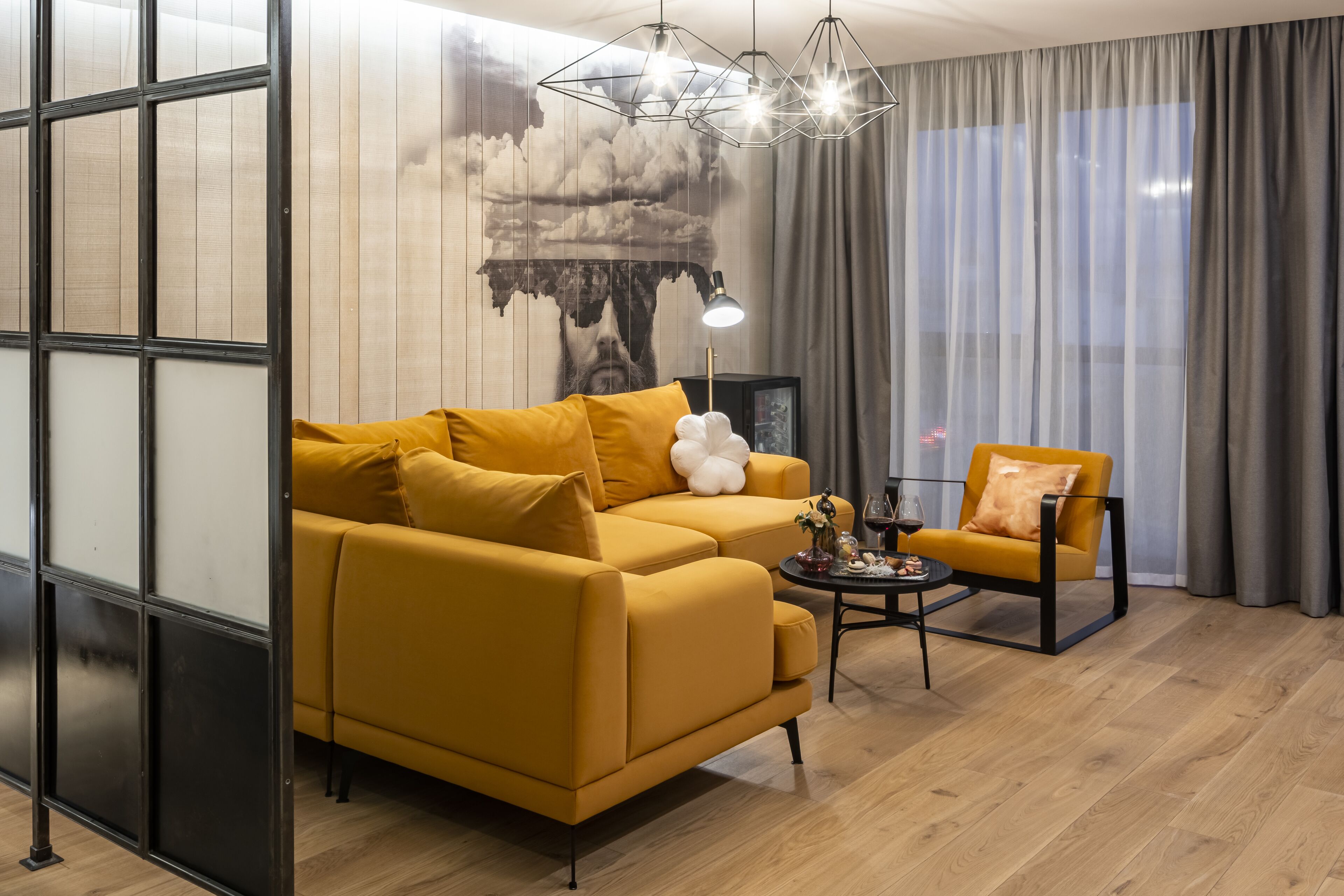 A modern living room with a yellow sofa, a side table, and a chair.