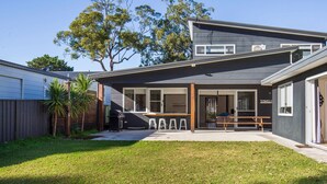 A modern two-story house with a covered patio, a barbecue area, and a visible garage. - Ginger's - Pet Friendly - 4 Min Walk to Beach (Callala Beach)