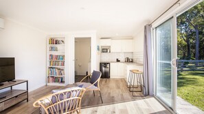 Un appartement moderne comprenant un salon, une cuisine et un balcon avec vue sur l’extérieur.