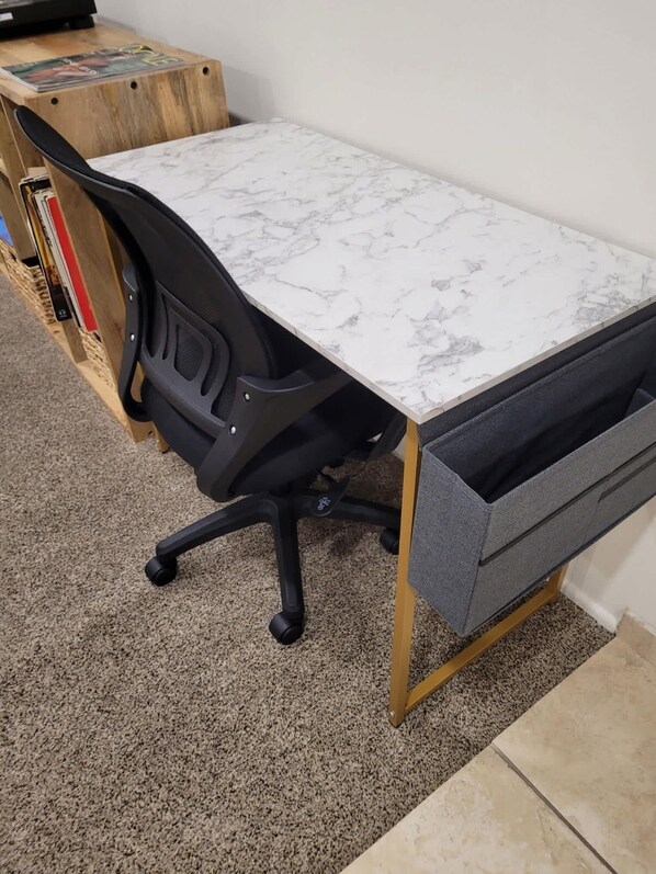 A small office space with a white marble desk, black office chair, and a grey drawer unit. - Private Pool & Spa · Game Room · Near Coachella (Indio)