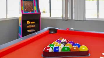Enjoy a game of pool or challenge friends to an arcade game in this lively room with a large window offering a view of the surrounding greenery.