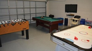 A room with a foosball table, a pool table, and an air hockey table. - IPG Florida Vacation Homes Bella Piazza Resort (Clermont)