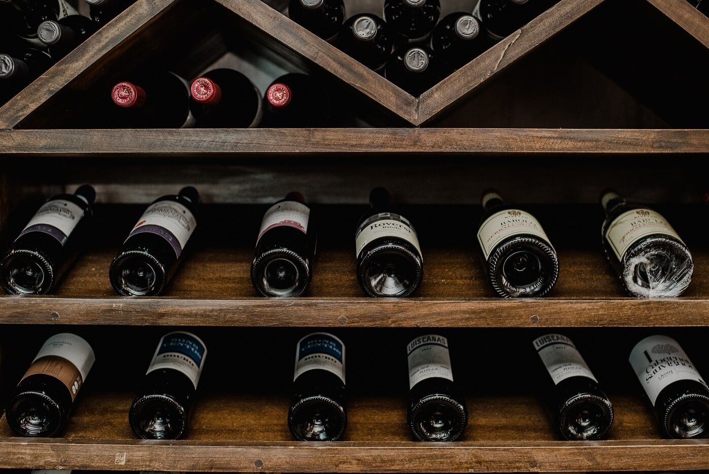A wooden wine rack with multiple bottles of wine.