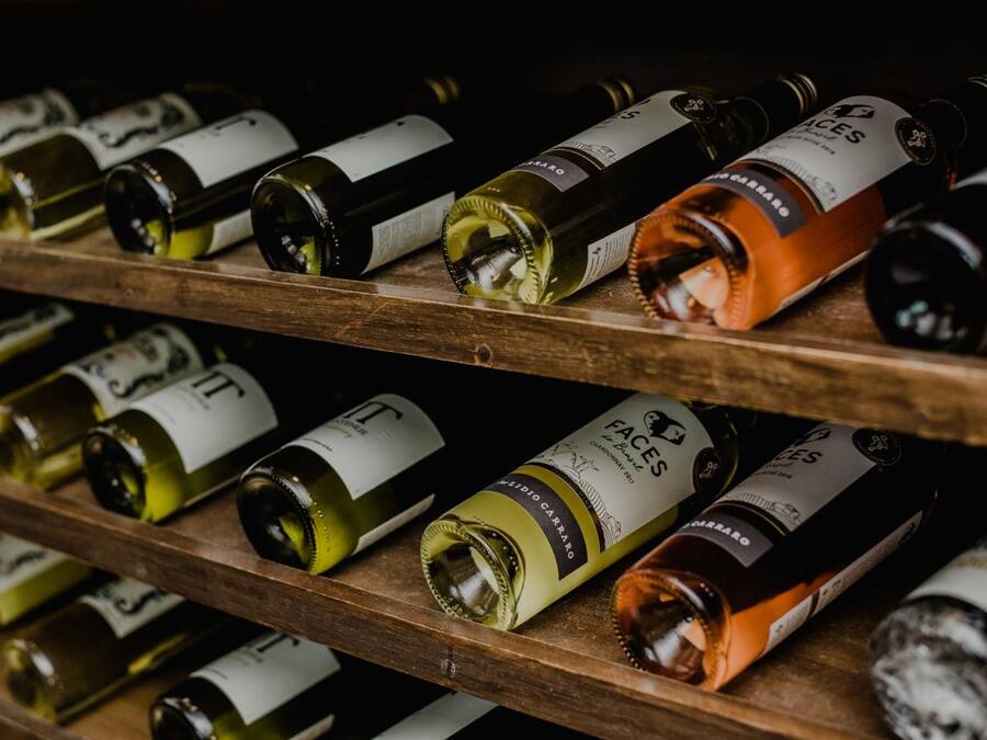 A collection of wine bottles on wooden shelves.