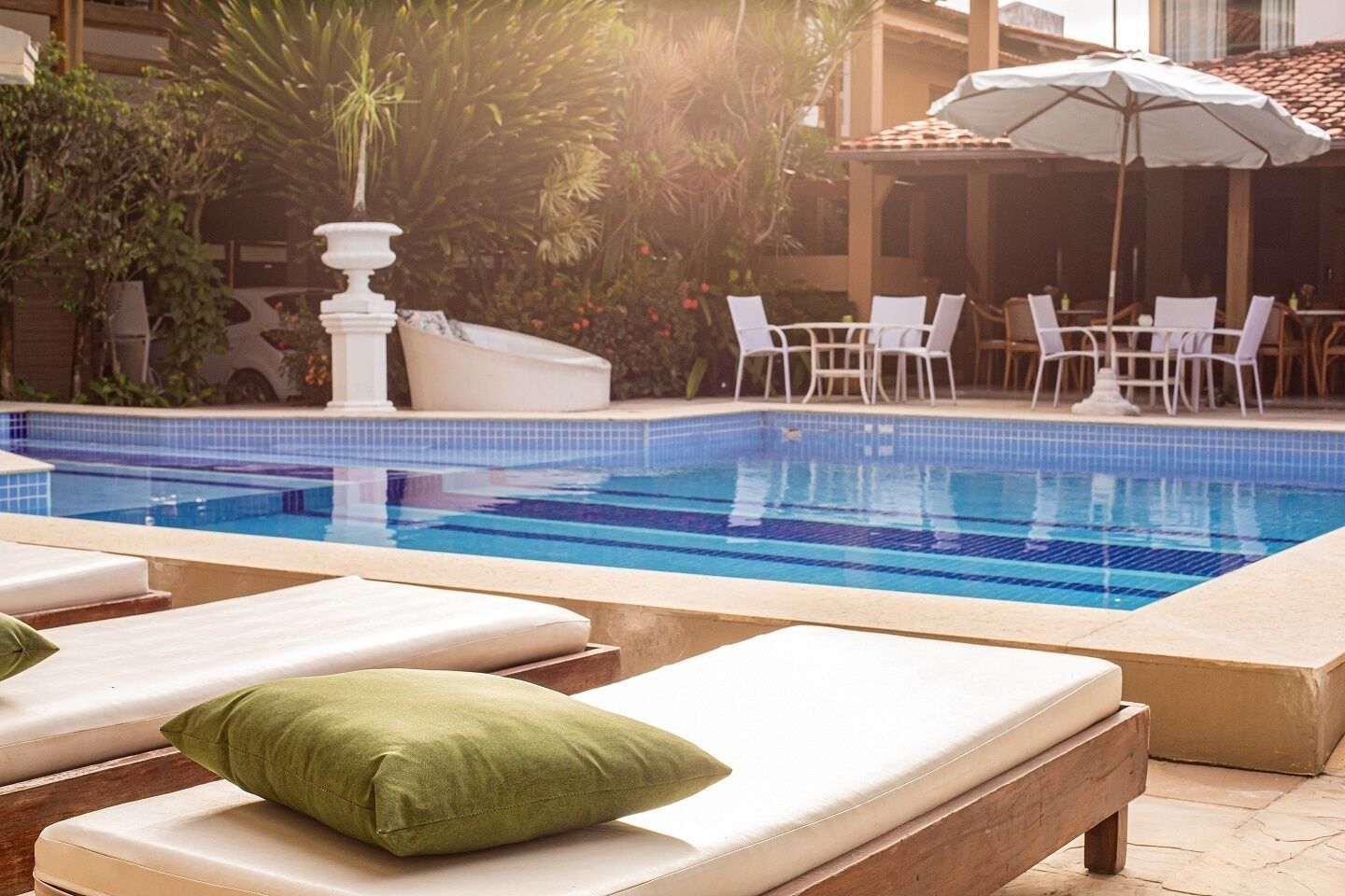 Una piscina al aire libre, sillones reclinables de piscina