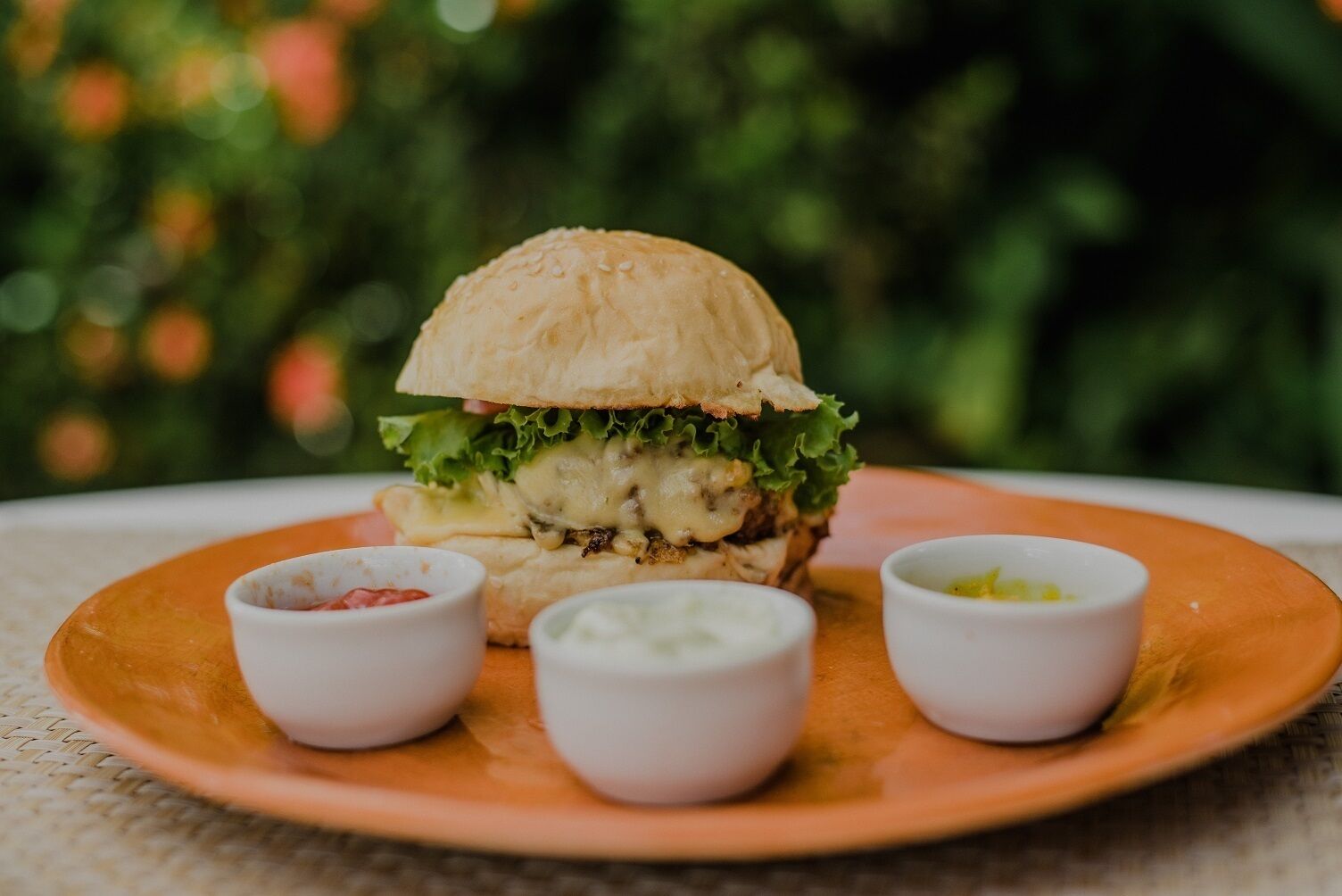Una hamburguesa con lechuga y salsa en un plato.