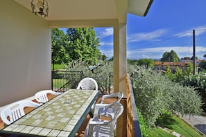 Enjoy a serene view of the lush garden from this balcony, perfect for two, with a table and chairs.
