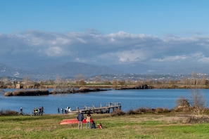 Escena junto al lago con un muelle, gente y bicicletas.