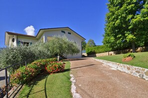 Surrounded by lush landscaping, this single-story house features a charming sloped roof and a cozy chimney.