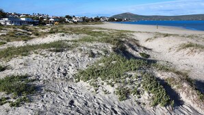 Una playa con vista despejada al mar y un pueblo distante.