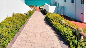 A paved pathway leading to a building with a view of the sea. - 99 Steps, Langebaan 8-sleeper (Langebaan)