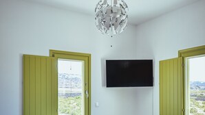 Uma sala de estar moderna com um sofá, uma mesa de centro e uma televisão de tela plana na parede.