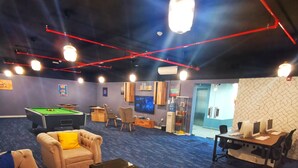 A room with a pool table, sofas, a coffee table, and a TV. - Resivation Hotel (Dubai)