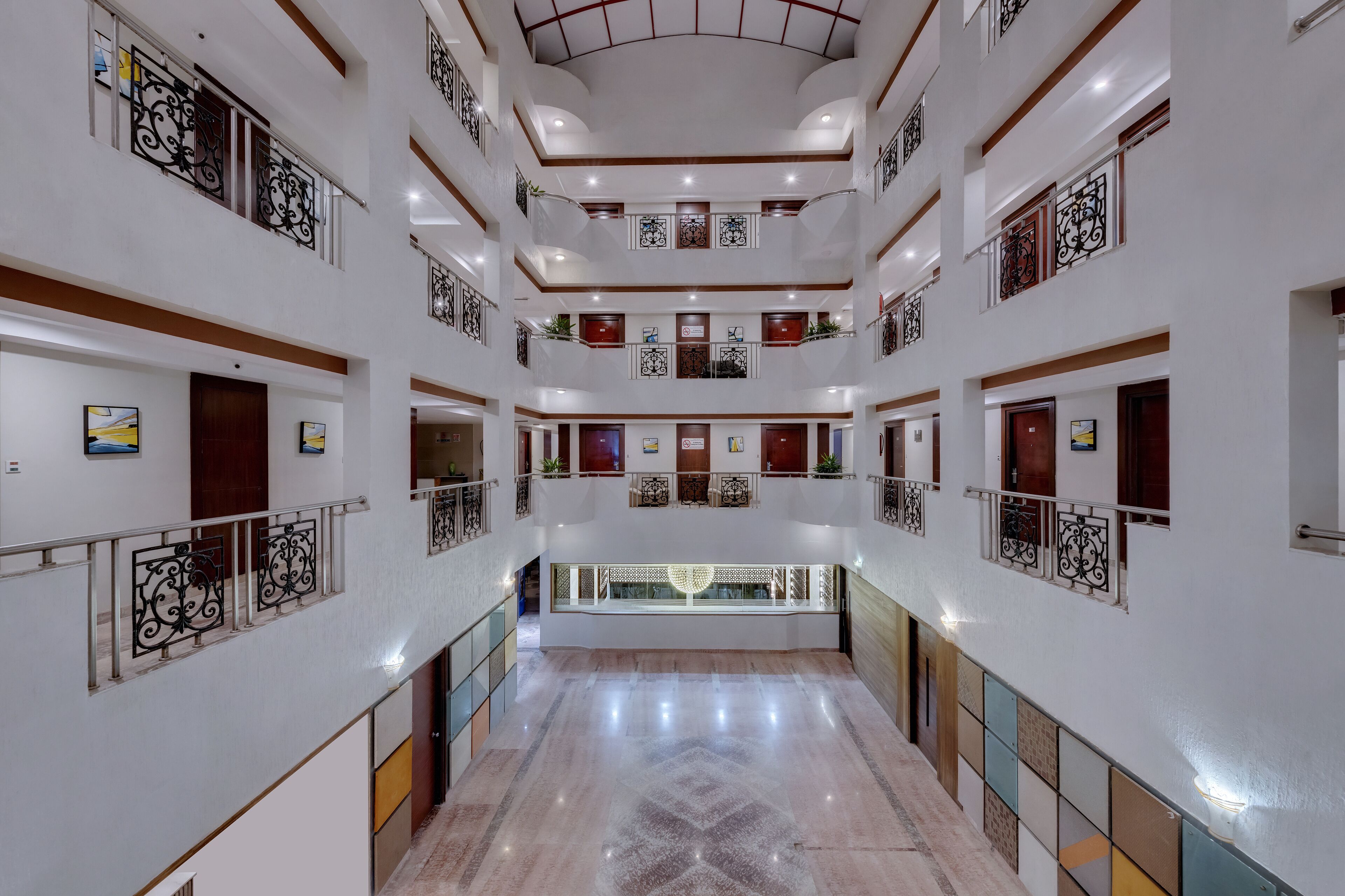 A multi-level hotel lobby with a central open space, multiple balconies, and a polished marble floor.