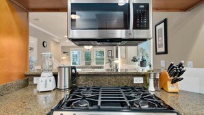 A kitchen with a gas stove, microwave, blender, and a coffee maker. - Perch - Cozy Ensuites: 3BR/3BA townhome with parking (Seattle)