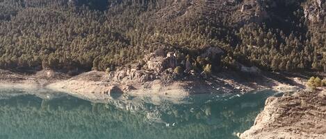 Un lac paisible dont les eaux claires reflètent la forêt environnante et le paysage rocheux.