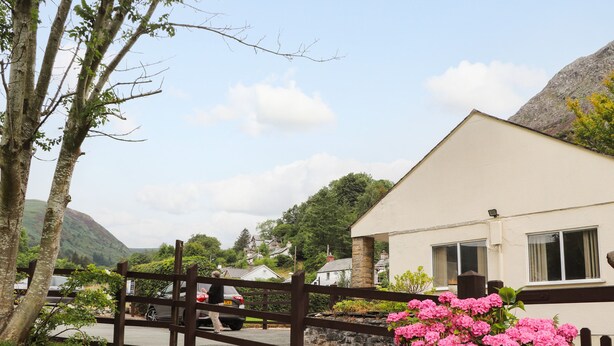 A house with a white exterior and a brown fence in front. - Awel Y Berwyn (Oswestry)