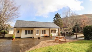 A two-story house with a stone facade, a tiled roof, and a gravel driveway. - Awel Y Berwyn (Oswestry)
