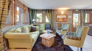 A cozy living room with a sofa, armchairs, a coffee table, and a fireplace. - Le cœur des Evettes - One Bedroom Apartment, Sleeps 4 (Flumet)
