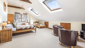 A spacious attic bedroom with a large bed, a desk, a chair, and a television. - Spacious and Characterful 3 bedroom Detached Barn Conversion close to coast. (Hartland)
