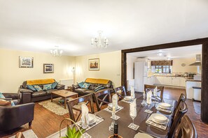 A living room with a dining area, a kitchen in the background, and a chandelier. - Spacious and Characterful 3 bedroom Detached Barn Conversion close to coast. (Hartland)